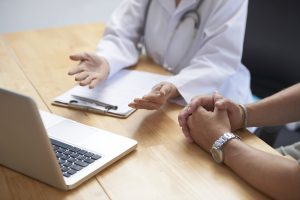 Doctor and patient discussing upcoming surgery at table